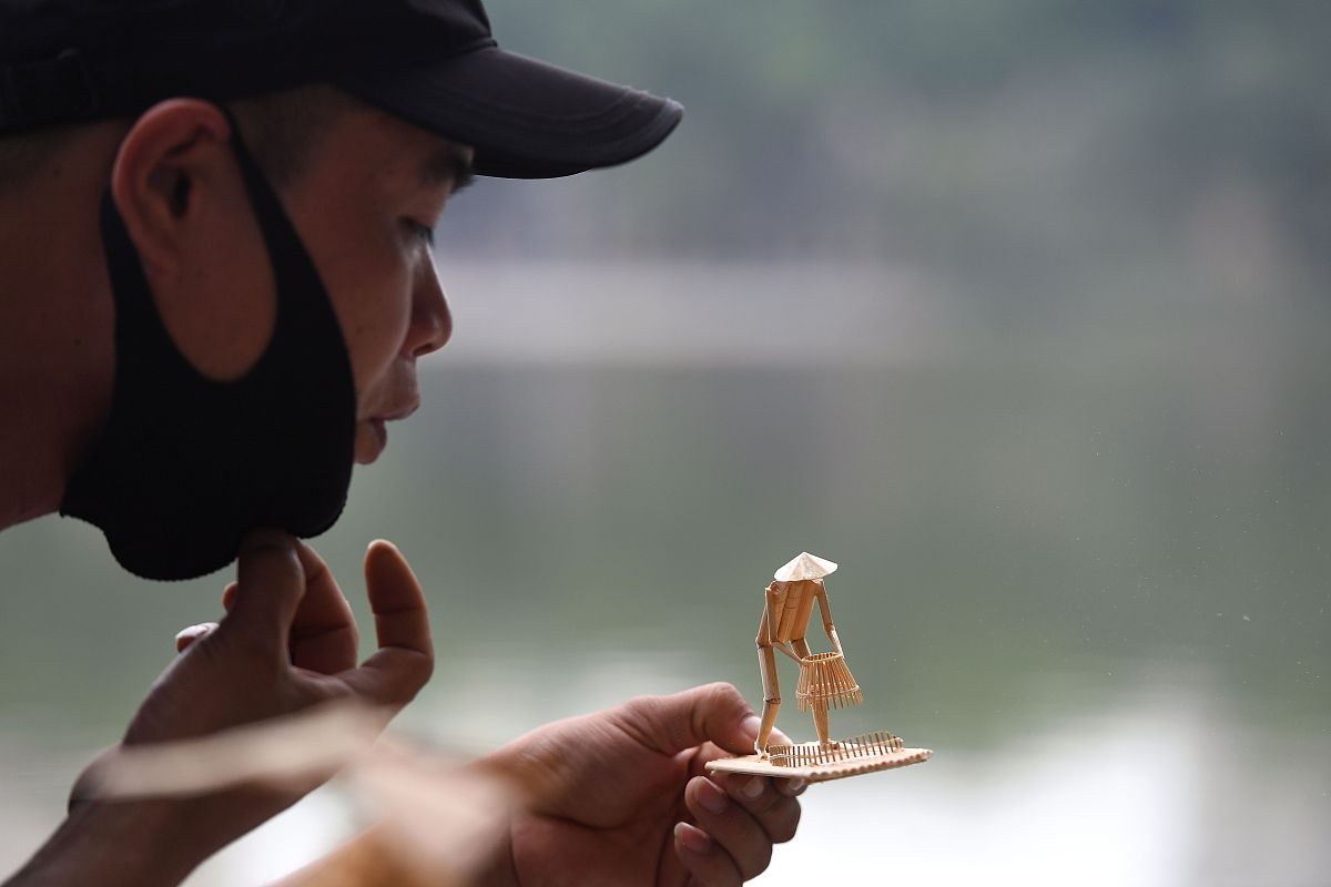 当地时间2020年11月25日,越南河内,一名越南男子展示他制作的微缩竹雕