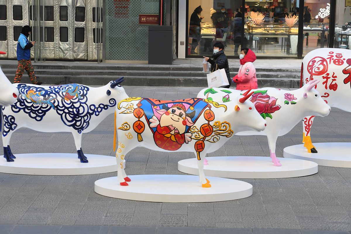 2021年1月1日,在沈阳中街街头,十头"彩牛"与市民见面,引来过往市民纷
