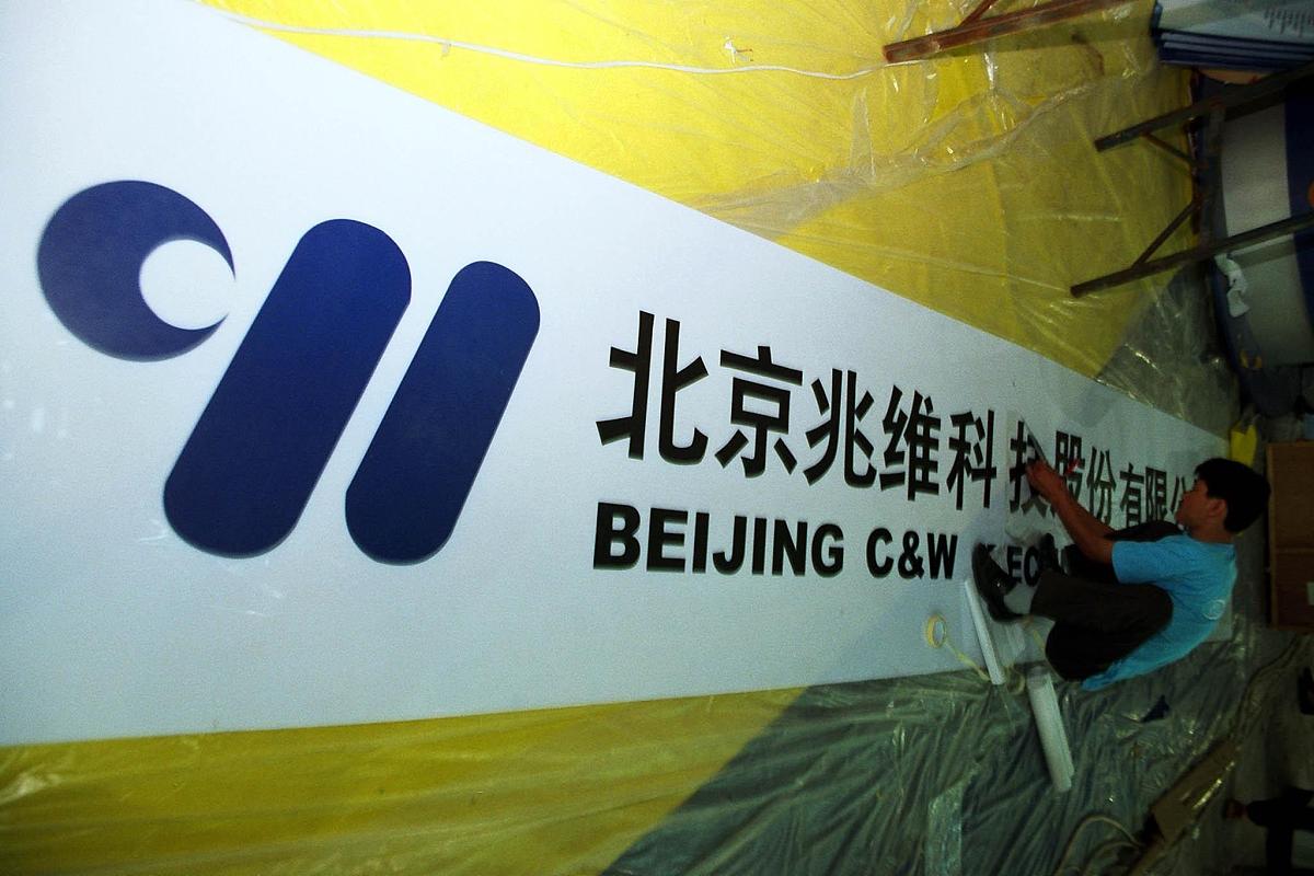 北京兆维科技股份公司的牌匾正被工人制作着.+++_+++国际科技产业博览
