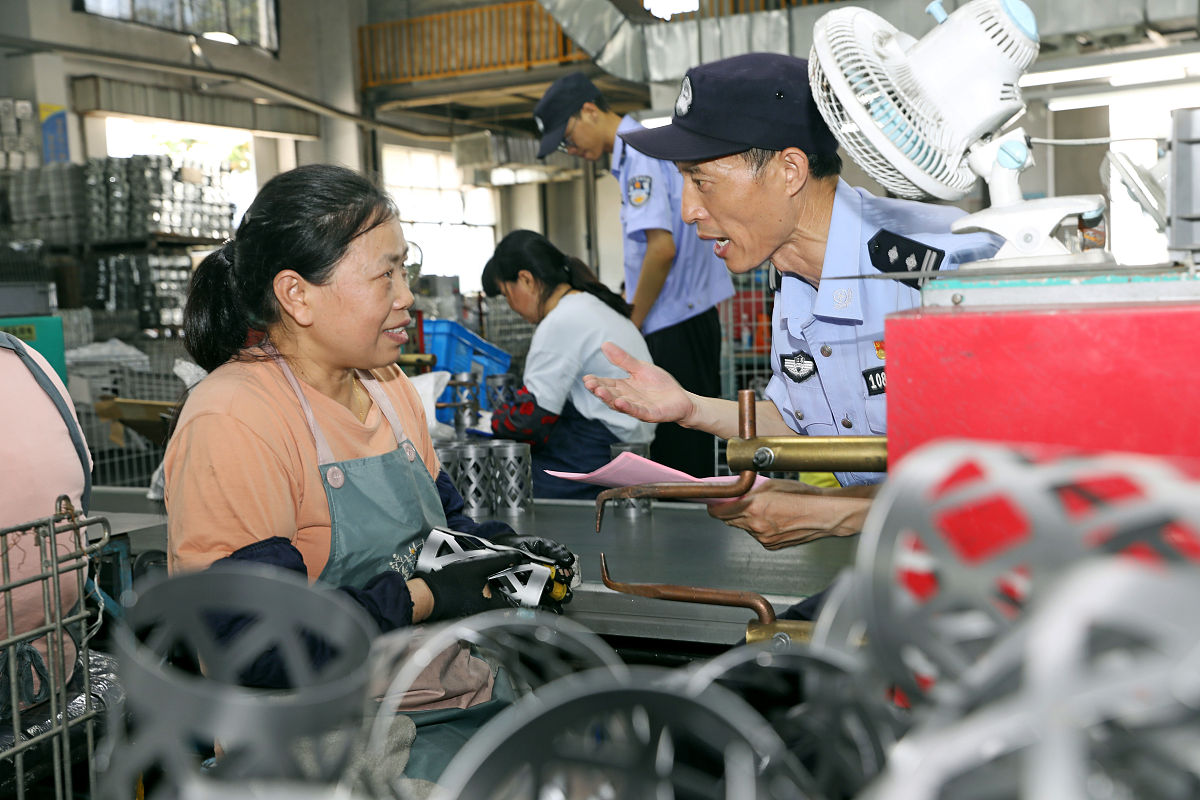 2021年7月14日,江苏扬州,民警在宝应县安宜镇一家企业车间里,向职工宣