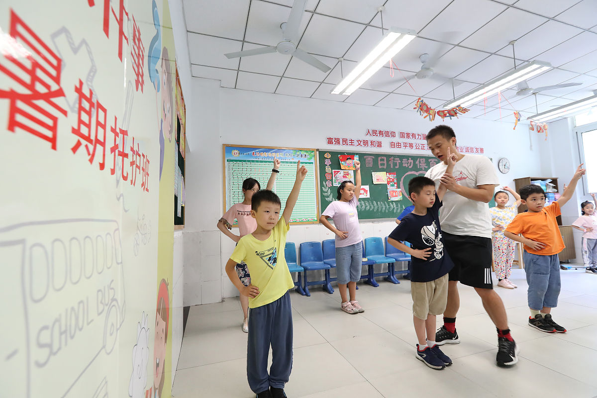 2021年7月14日,重庆市沙坪坝区凤鸣山小学,志愿者在教暑假托管班的孩