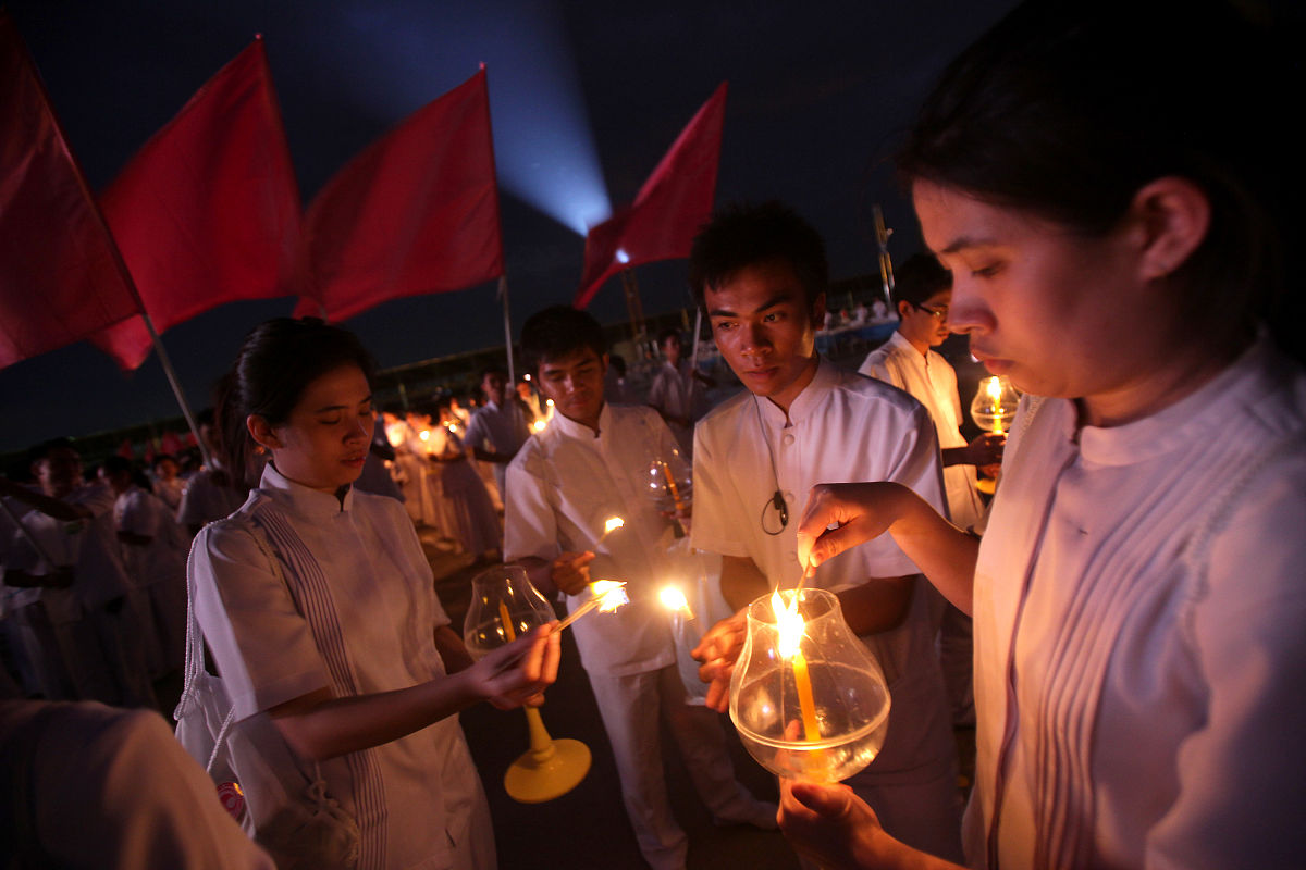 2012年3月7日,泰国巴吞他尼府,数千名僧侣坐在灯烛旁诵经,庆祝万佛节.