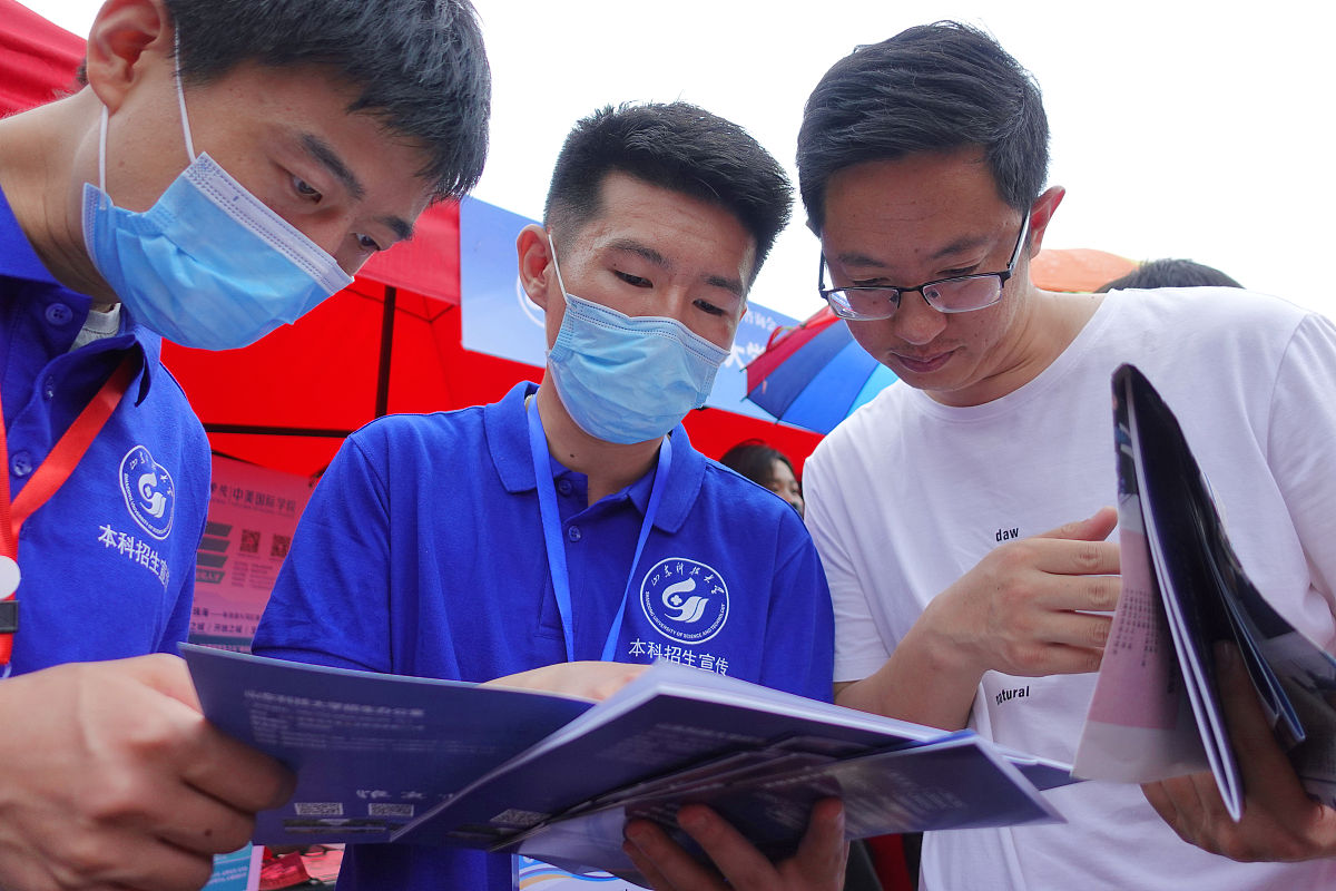 2021年6月27日,在山东烟台鲁东大学,招生人员向考生家长介绍招生信息.