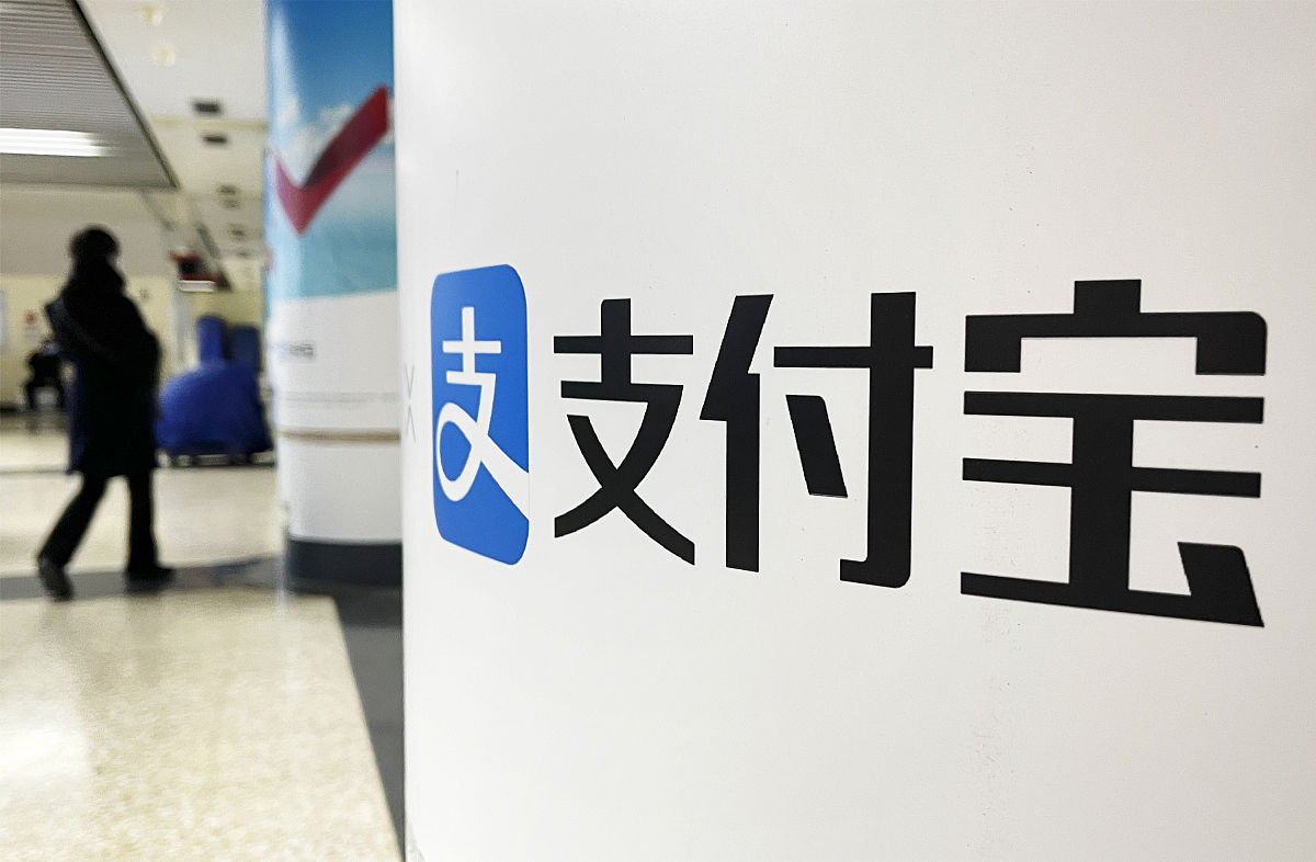 2021年12月12日,北京地铁站厅内,显示支付宝标志的广告牌.