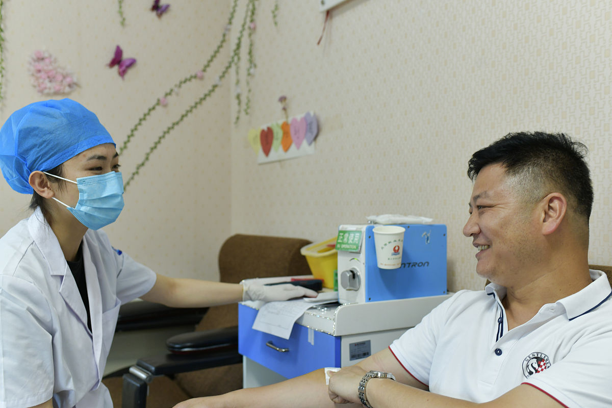 2020年6月13日,贵州省遵义市,郭兴伍在献血屋与医护人员交流.