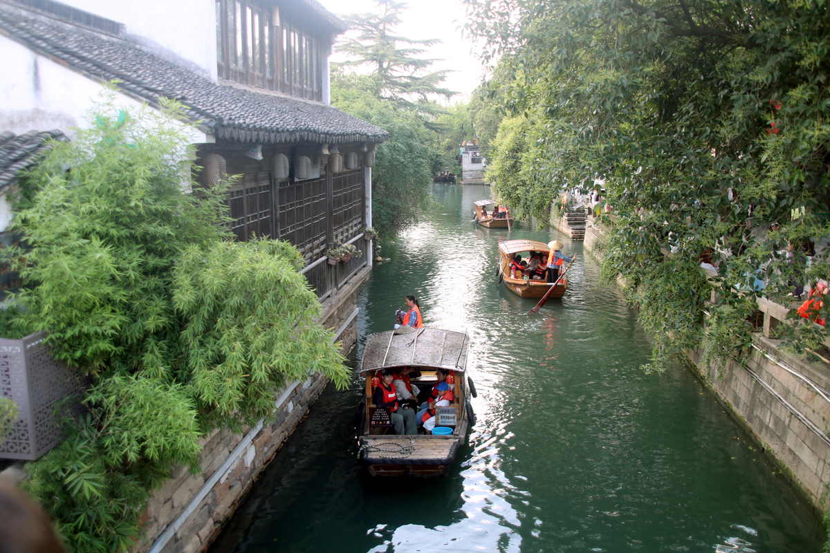 空中下着细雨江边的房屋青瓦白墙桥上的路人打着油纸伞雨滴敲打着船篷请700字的烟雨江南作文