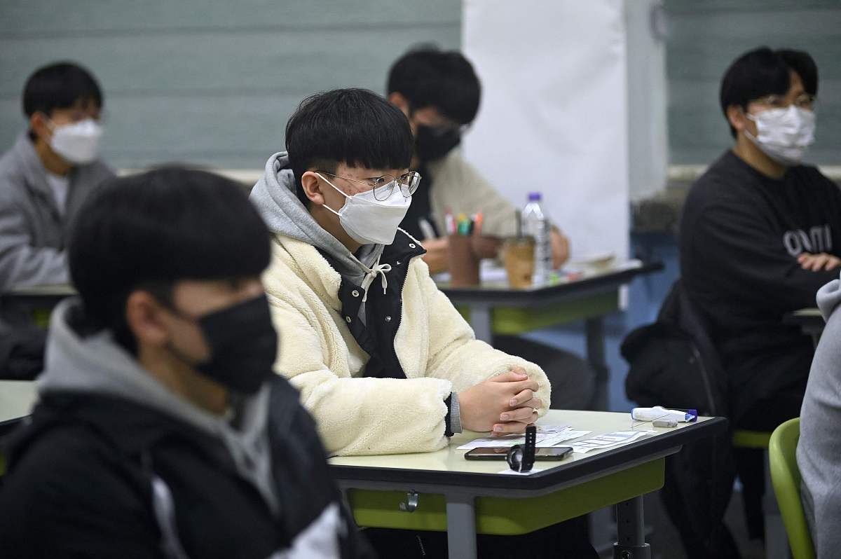 当地时间2021年11月18日,韩国首尔,考生们相继进入考场.韩国2022学年