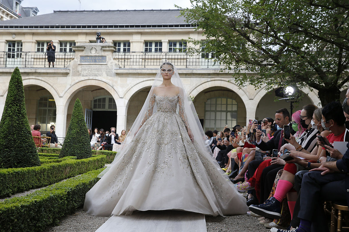 请用简洁准确的中文翻译A year later Wang wasnt pregnant but with a $4 million check from her father and no day job she was free to open her own bridal store on Madison Avenue and a custom-order salon just across