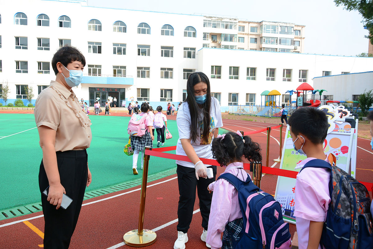 2021年8月23日,吉林,小学生们通过老师严格的测温后正式回归校园,开启