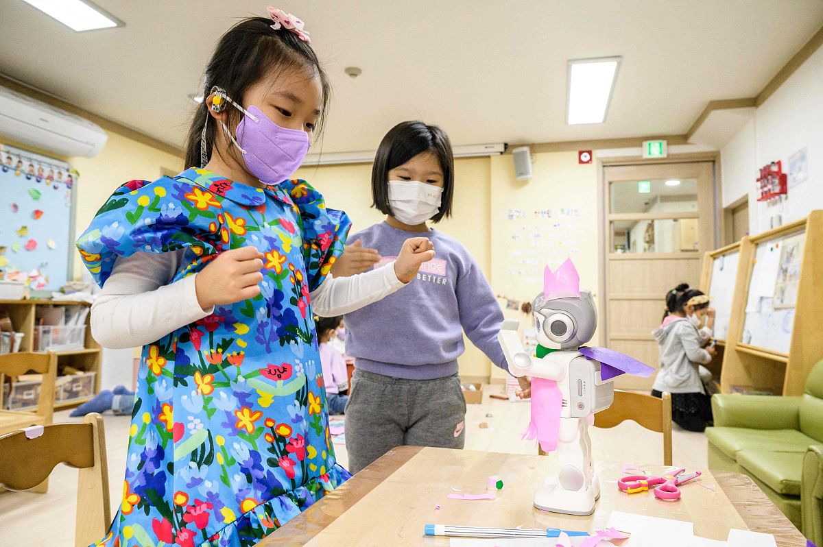 当地时间2021年11月23日,韩国首尔,当地幼儿园课堂上小朋友们与一个大