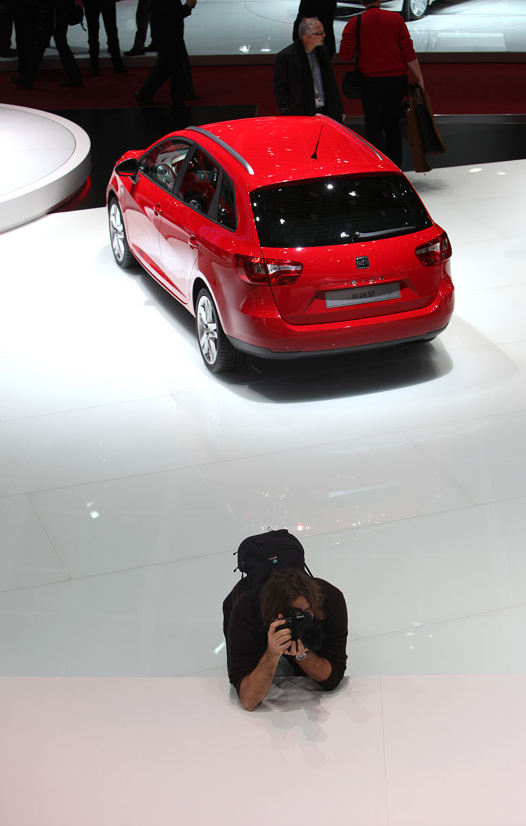 一名摄影师坐在西亚特展位,背后是一辆tbiz st<strong>汽车</strong>.