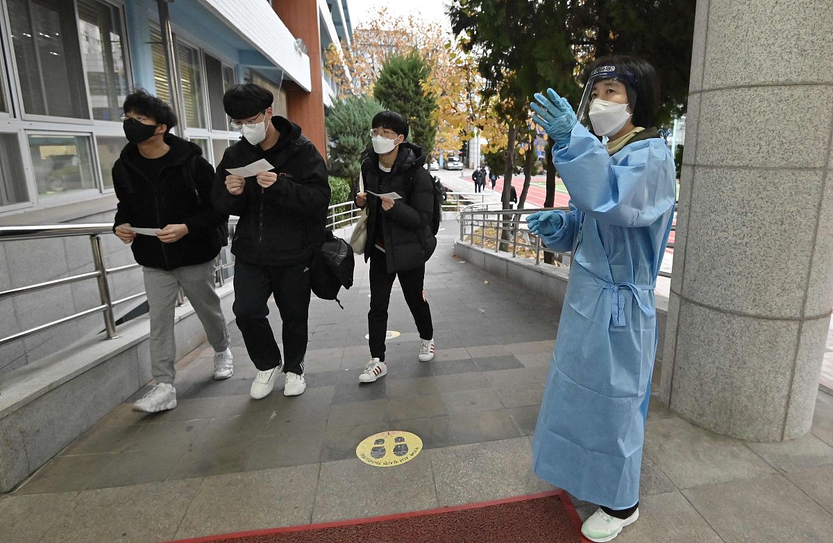 当地时间2021年11月18日,韩国首尔,考生们相继进入考场.韩国2022学年