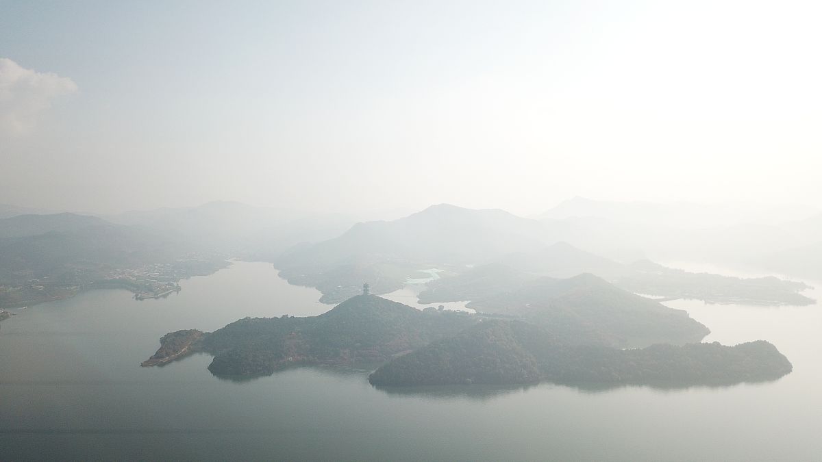 2018年10月17日,北京平谷金海湖被一片薄雾笼罩,宛如一副山水画卷,甚