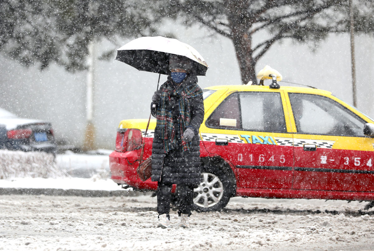 2021年3月20日,吉林延边,行人在风雪中匆匆赶路.