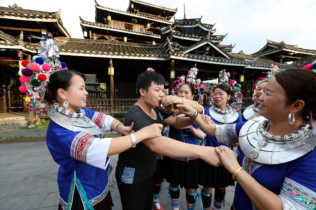 2018年8月8日,广西三江侗族自治县林溪镇,正在欢迎游客的侗家人.