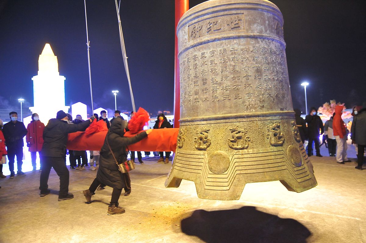 2021年12月31日晚上,哈尔滨冰雪大世界内,游客在灯光下游玩,等待跨年.