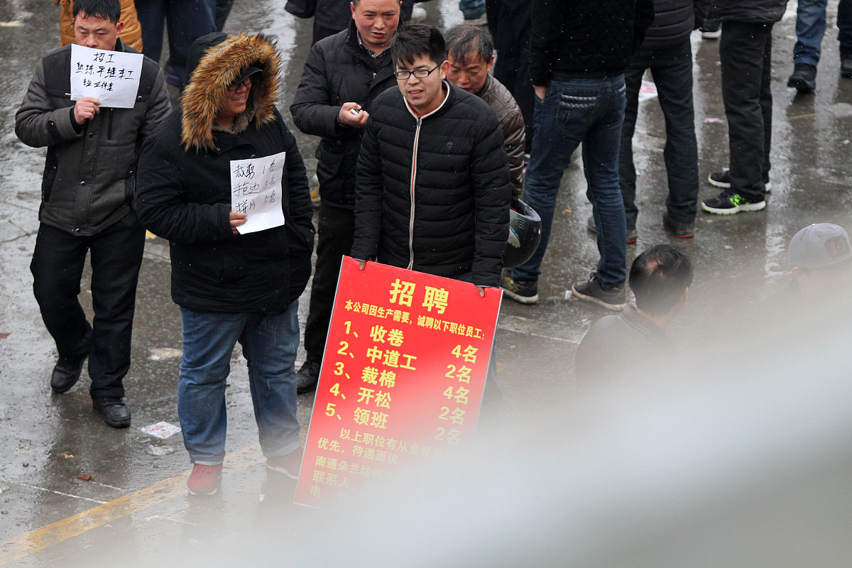   2014年2月19日,众多举着招工牌子的家纺企业招工人员聚集在江苏南通