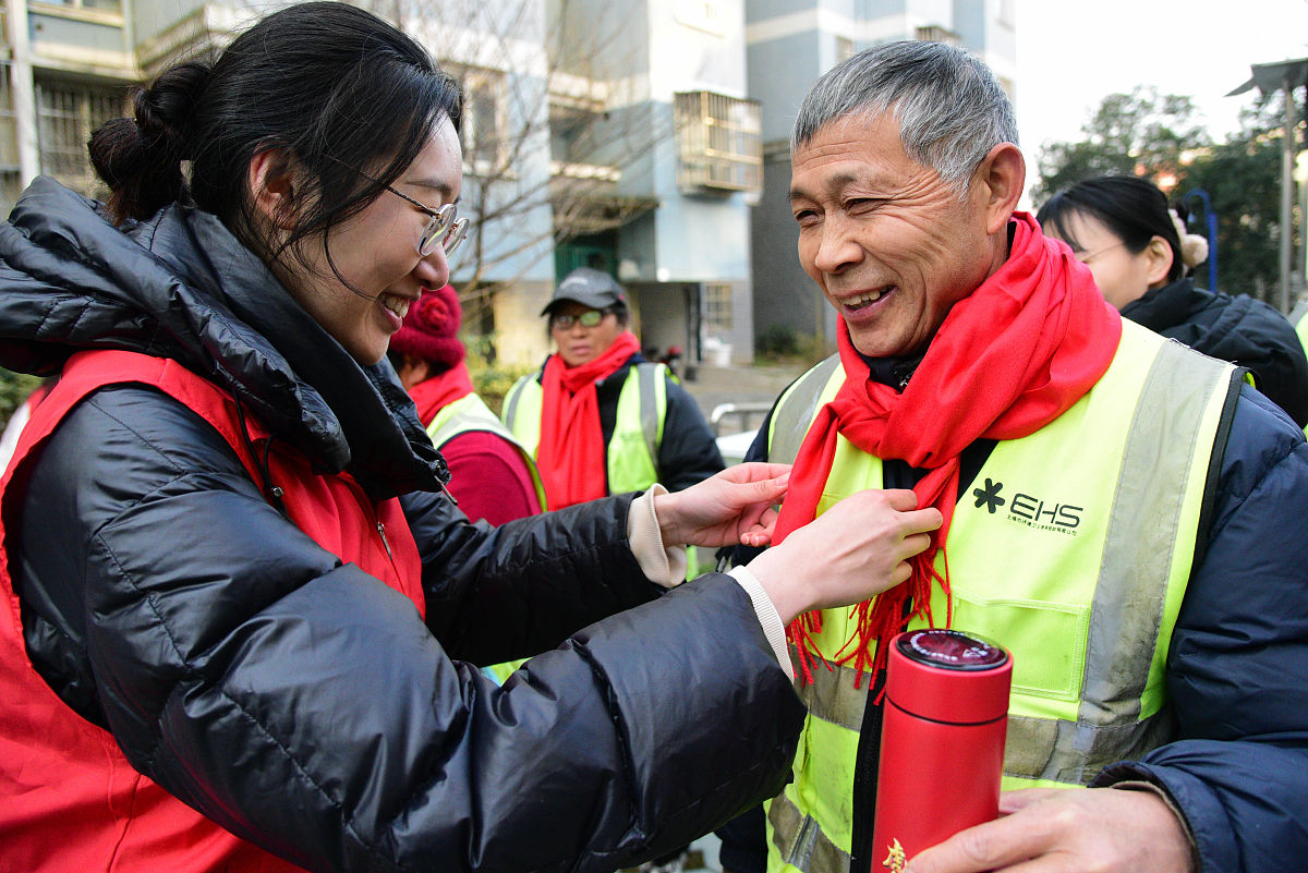 2022年1月13日,在江苏省镇江市新城社区,江苏大学志愿者在向环卫工人