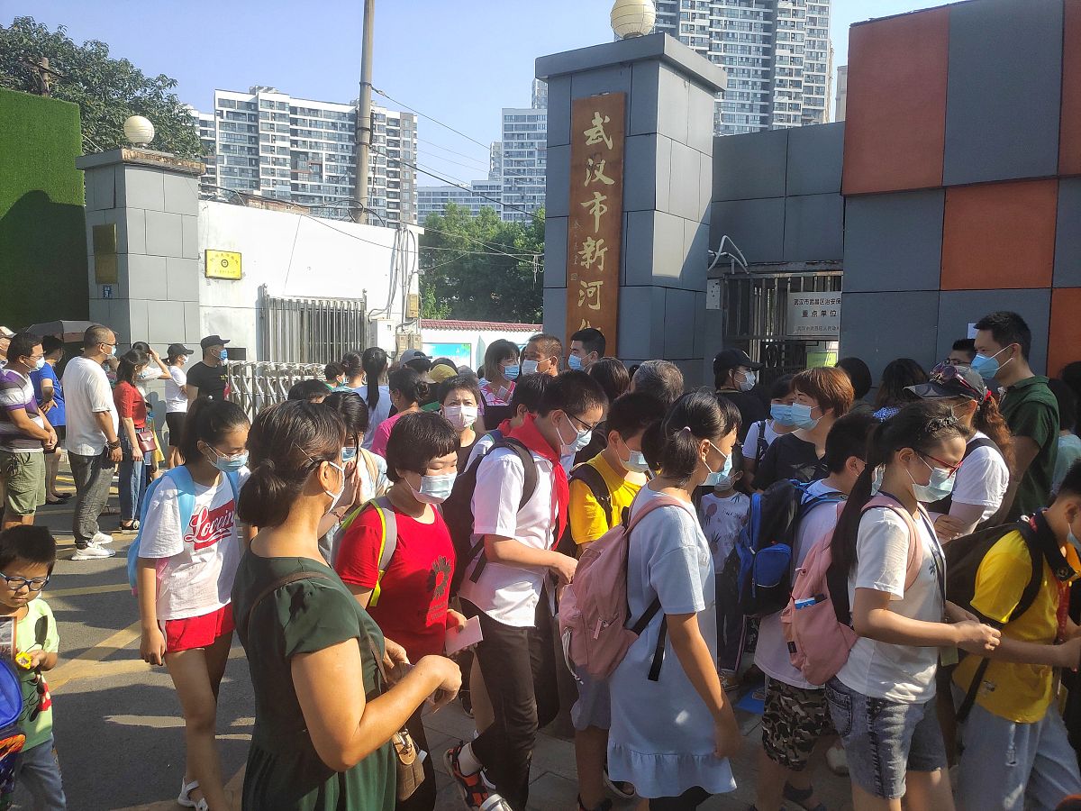 2020年8月31日,武汉一小学门前,家长等候开学报到的孩子走出校园.
