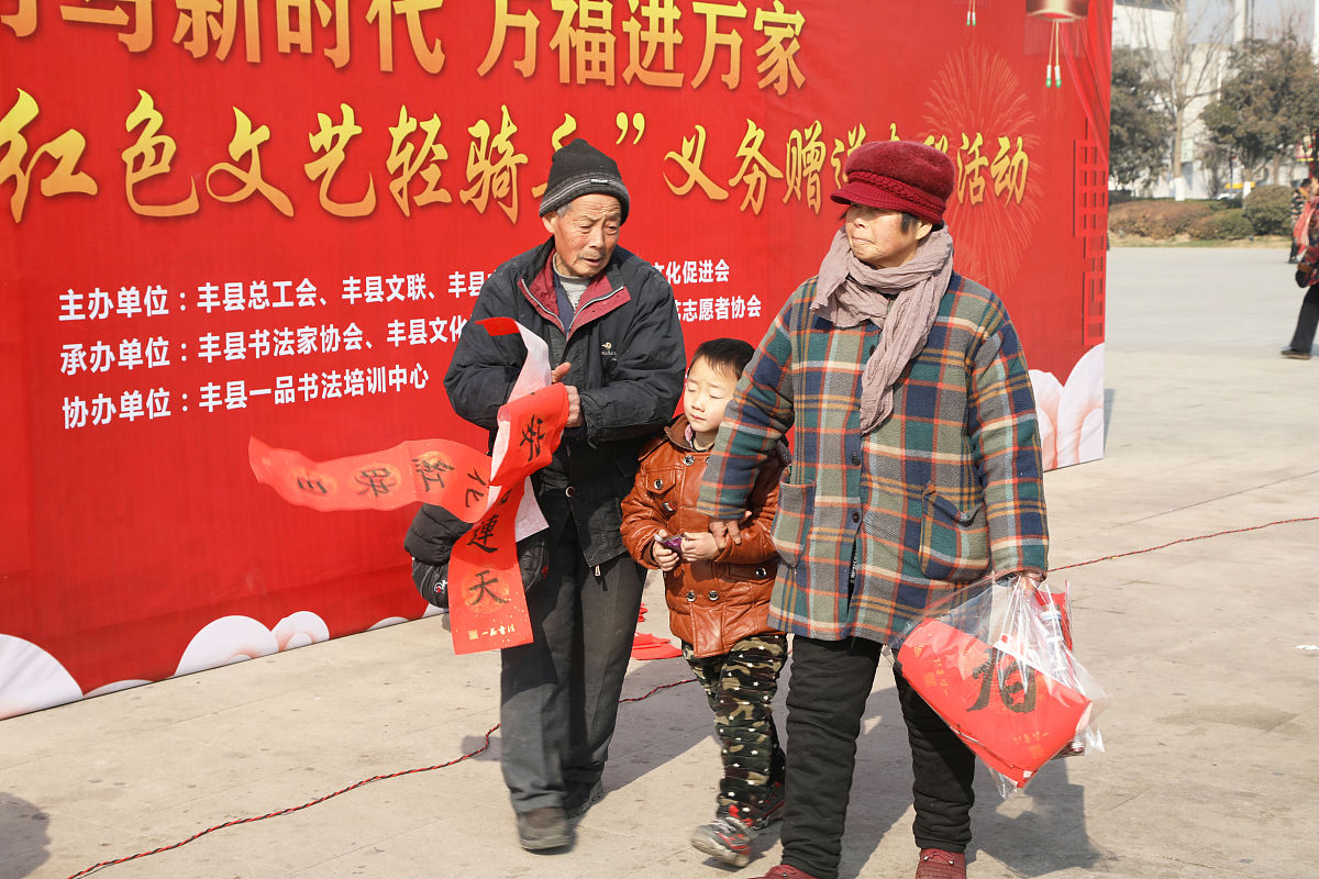 2018年2月7日,江苏徐州,青少年"书法家"为市民书写春联.