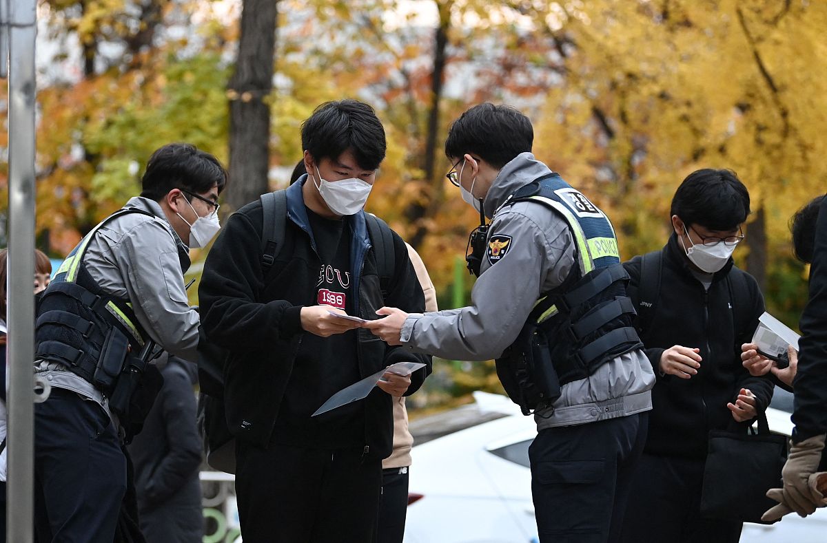当地时间2021年11月18日,韩国首尔,考生们相继进入考场.韩国2022学年