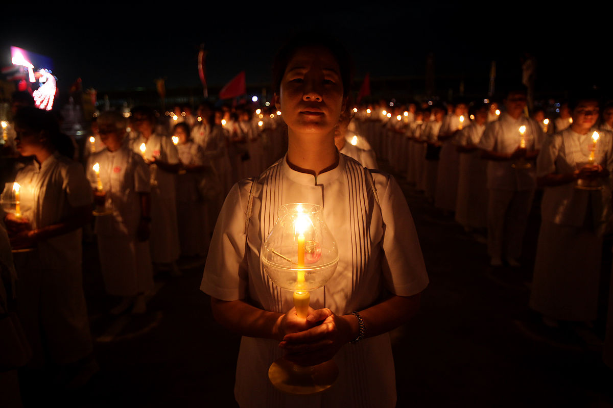 2012年3月7日,泰国巴吞他尼府,数千名僧侣坐在灯烛旁诵经,庆祝万佛节.