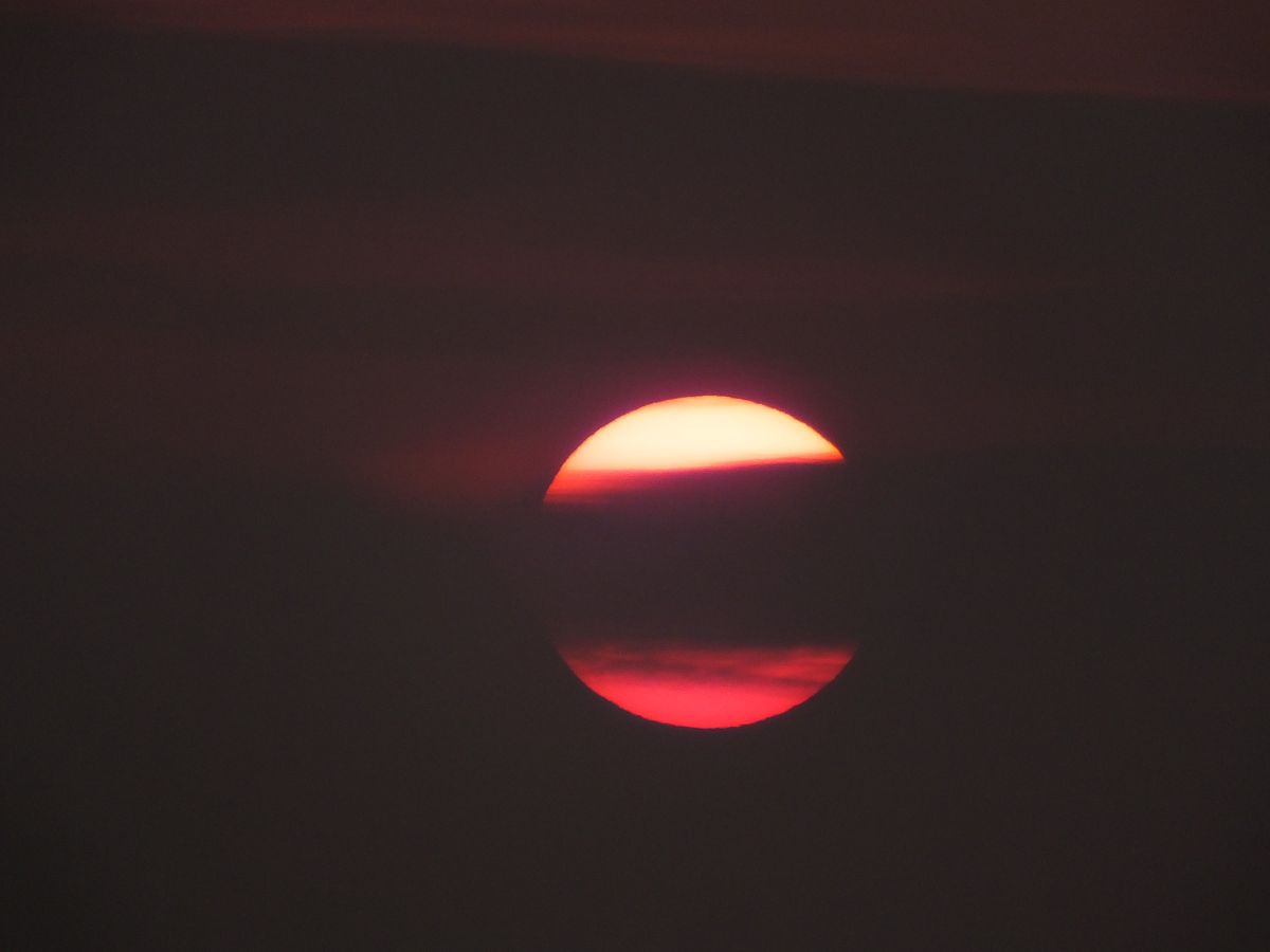 2021年4月8日,湖北宜昌,日出之时太阳在乌云中穿行.