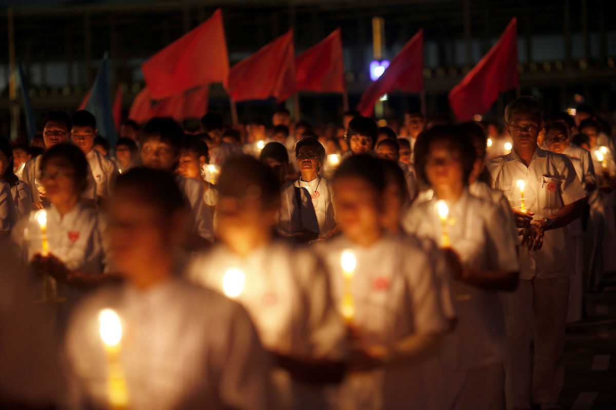 2012年3月7日,泰国巴吞他尼府,数千名僧侣坐在灯烛旁诵经,庆祝万佛节.