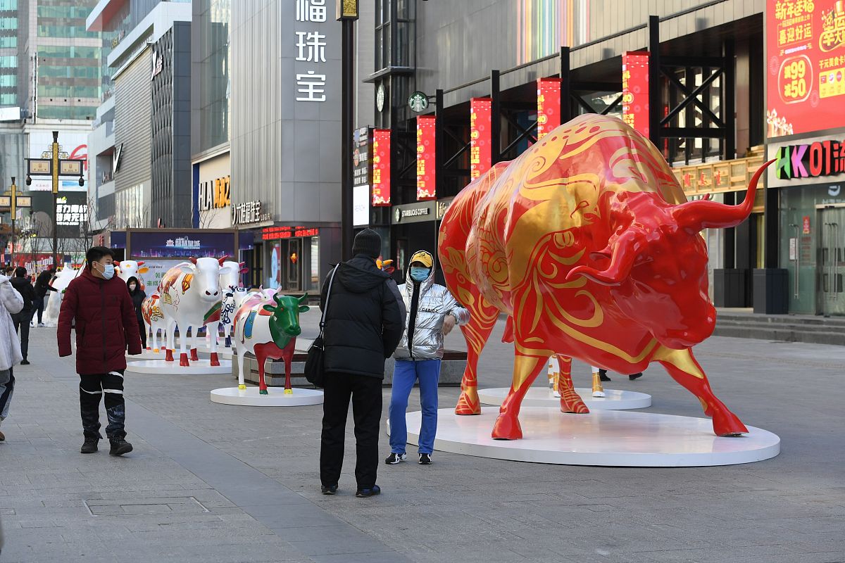 2021年1月1日,在沈阳中街街头,十头"彩牛"与市民见面,引来过往市民纷