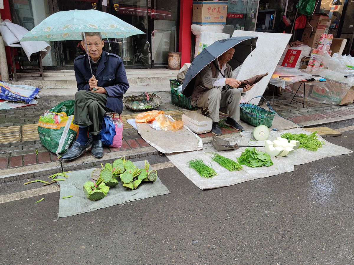 一个用白色帆布搭成的路边小摊上面有个红色的风扇小摊的主人不见踪影请用以上文字编写一段有诗意文案