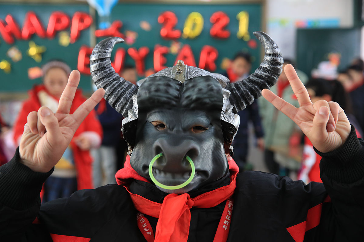 2020年12月31日,浙江宁波,牛年即将来临,一位男生戴上牛面具参加游园