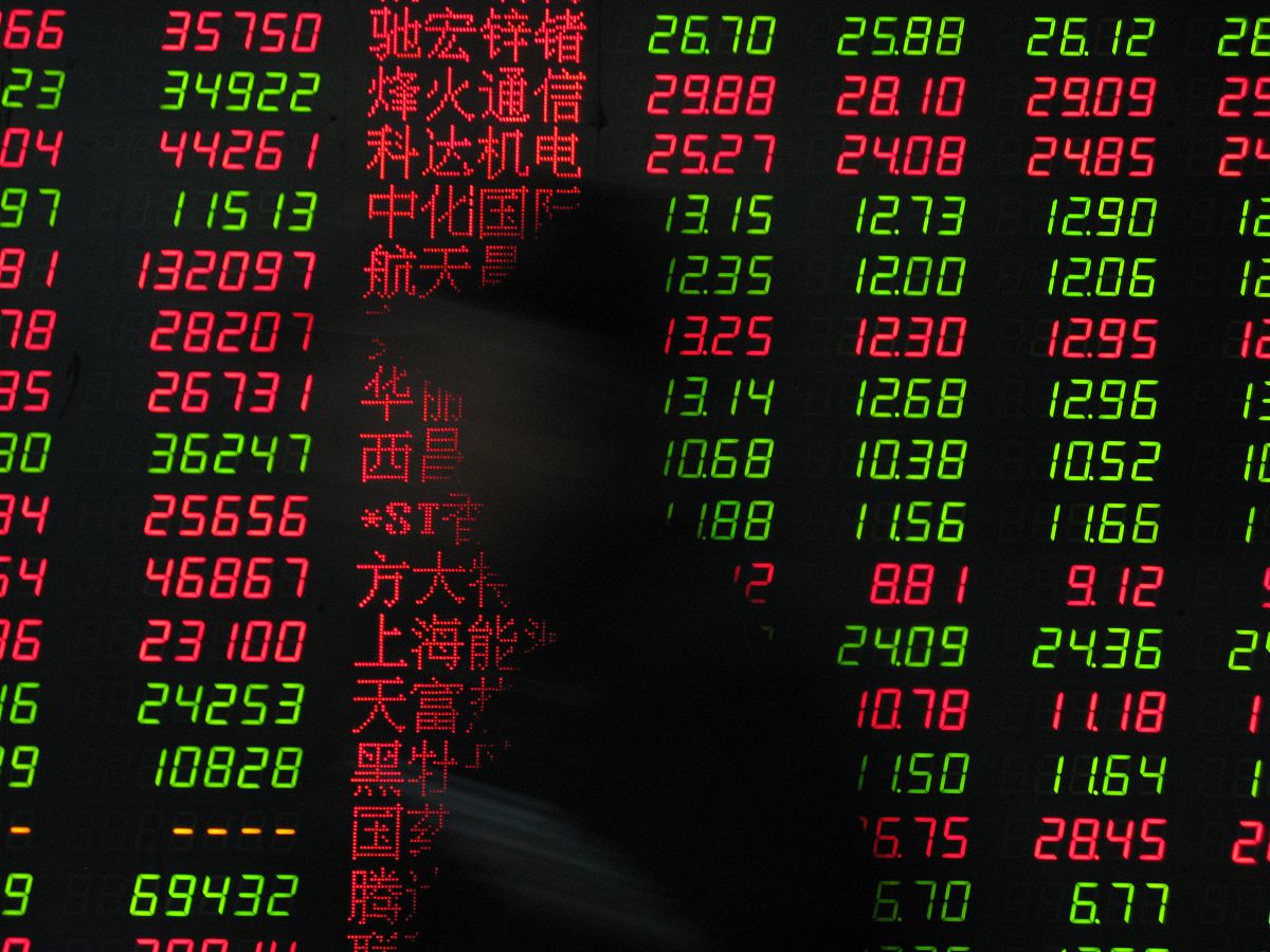 2010年1月13日,湖北十堰,股民从刊登有股市信息的大屏幕前经过.