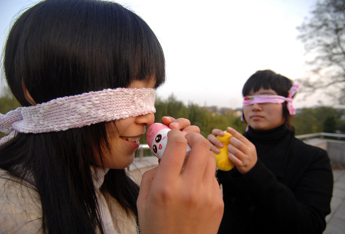 2009年12月02日, 扬州,体验盲人生活的大学生用手触摸物品.
