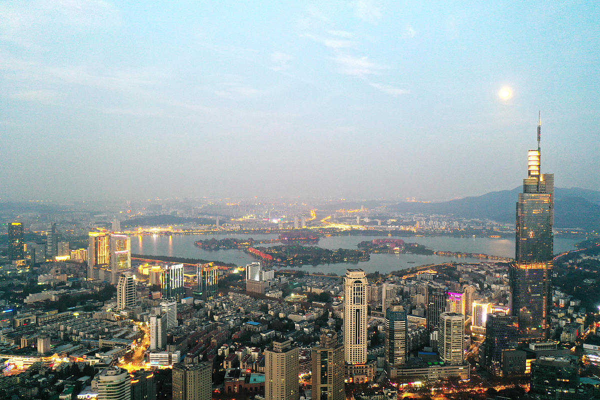 2020年11月29日,南京天气放晴,傍晚时分,月亮初上,灯光闪烁,将古城的