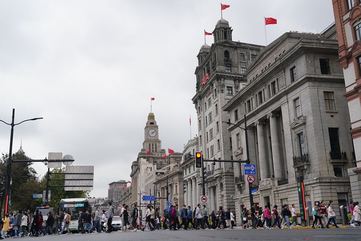2021年11月7日,行人在上海外滩建筑群穿行.上海外滩建筑群形成于20世