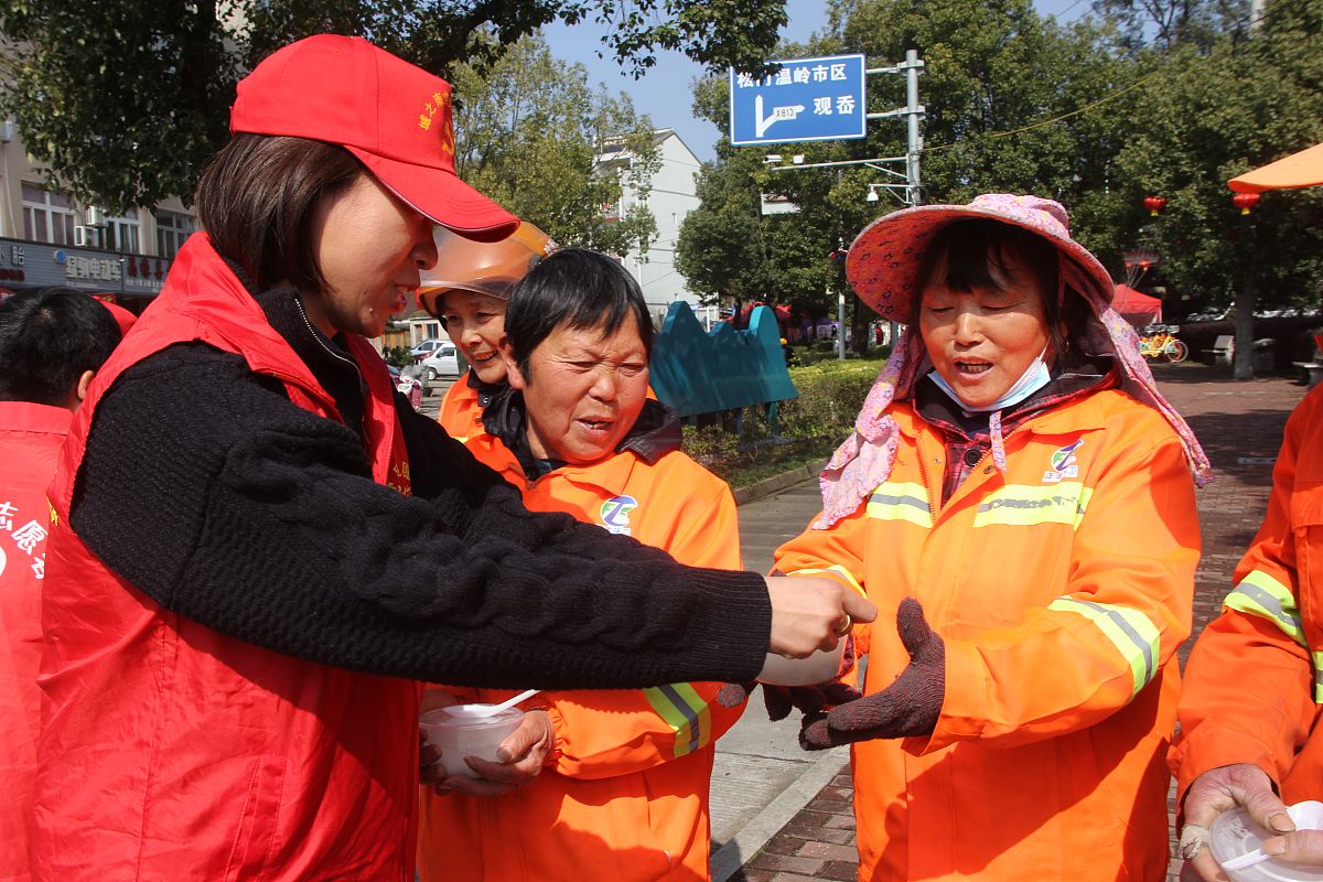 2022年2月14日,浙江台州温岭市大闾街头,城之南党员志愿者将热腾腾的