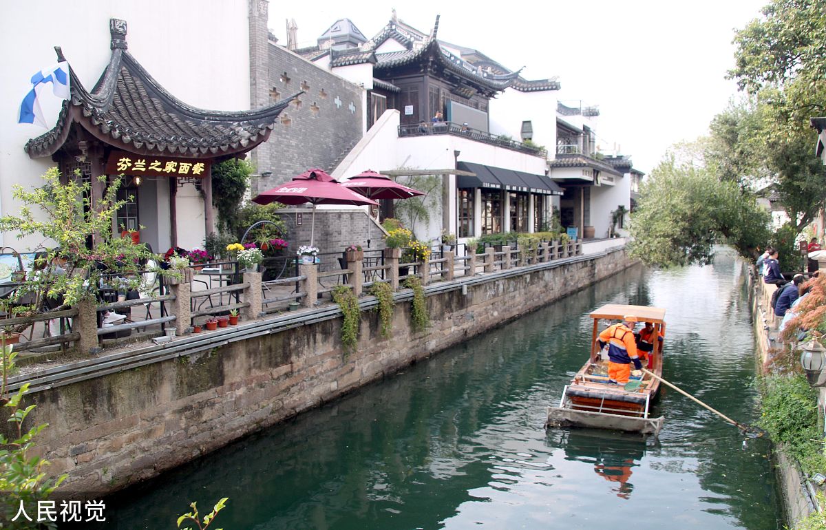 2020年4月12日,苏州,保洁工作人员乘船清理平江河面上的漂浮物.