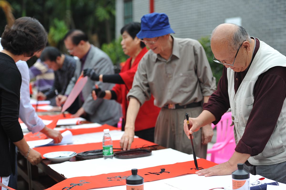2013年2月3日,海南琼海,书法家们在挥毫泼墨为村民写春联.+++_+++春联