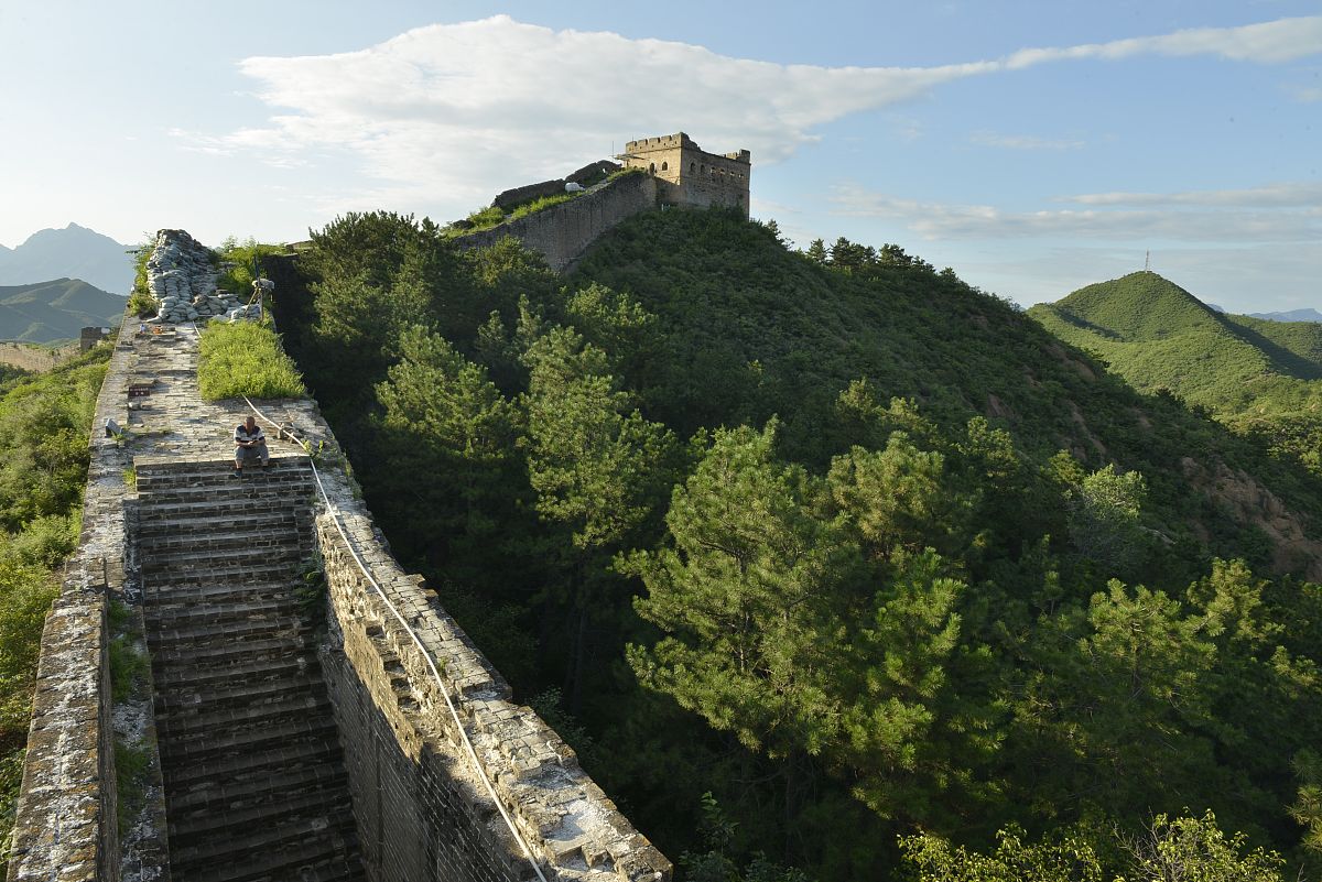 把下列句子改成比喻句：远看长城它在崇山峻岭之间蜿蜒盘旋。