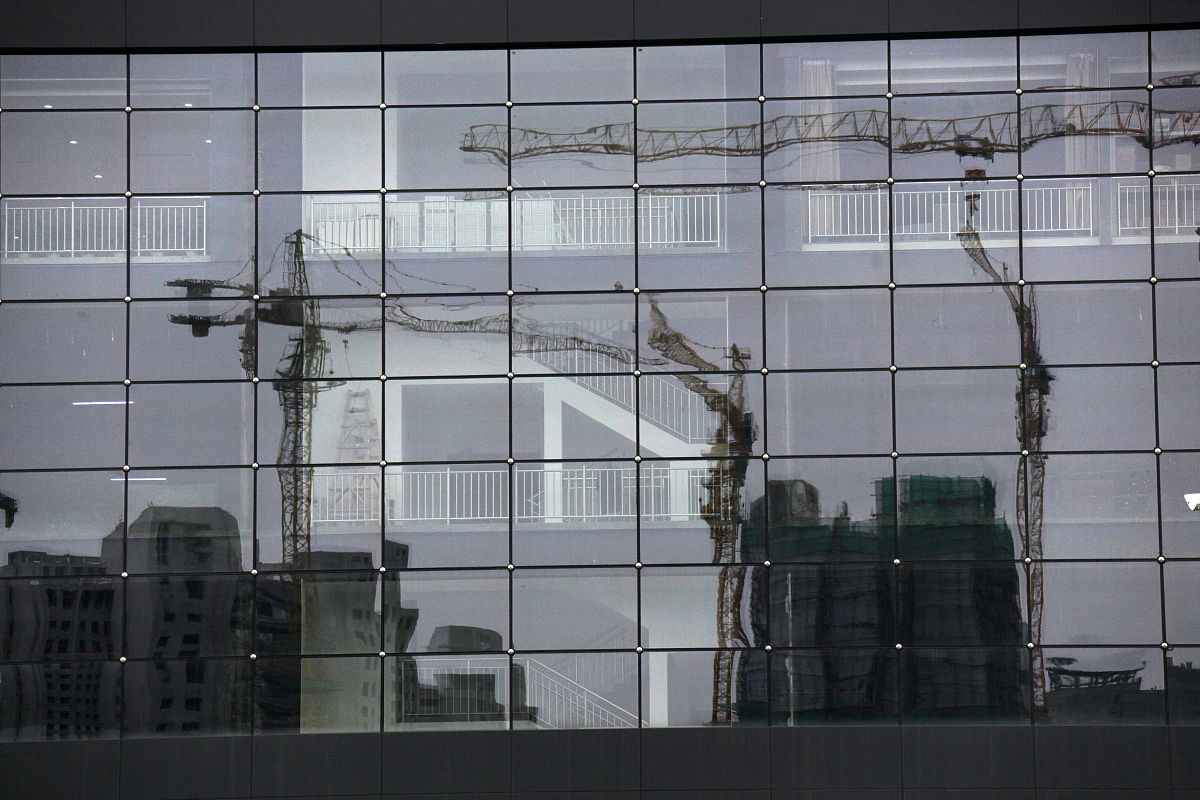 2020年7月16日,江苏省南京市城南的一处建筑工地映照在玻璃幕墙上.