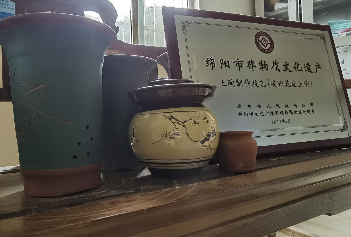 2021年4月9日,四川绵阳,陶器与"非遗"牌子.