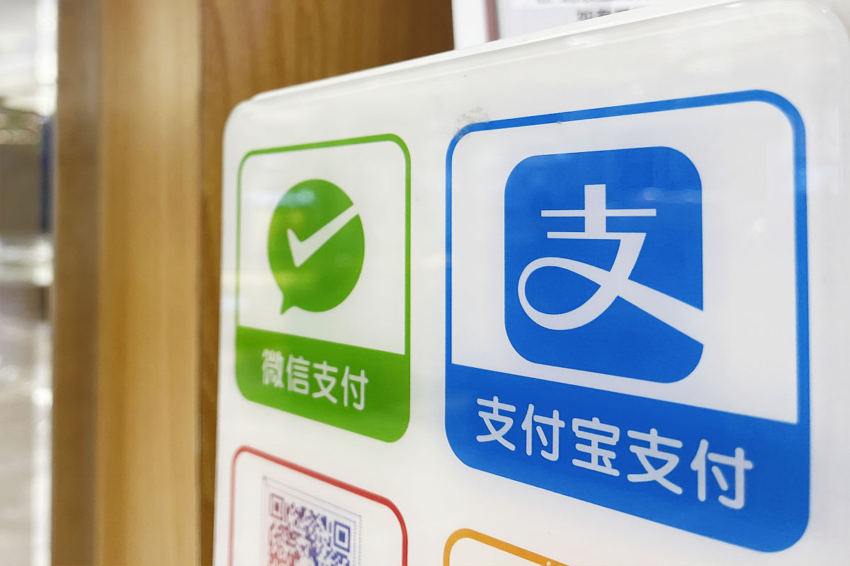 2021年7月10日,北京王府井百货大楼,收银台的支付宝和微信支付的手机