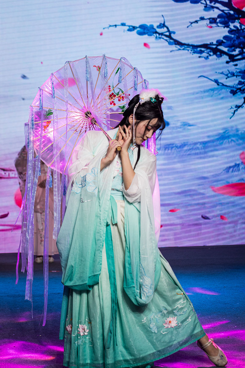 描绘词：曼妙、柔美、翩翩起舞、扇风拂面、轻柔舞步、婉转动作、芳华绝代、纤腰玉骨、霓裳羽衣、柳眉莲腮。关键词：唐装、美女、跳舞、舞步、扇子、曲调。