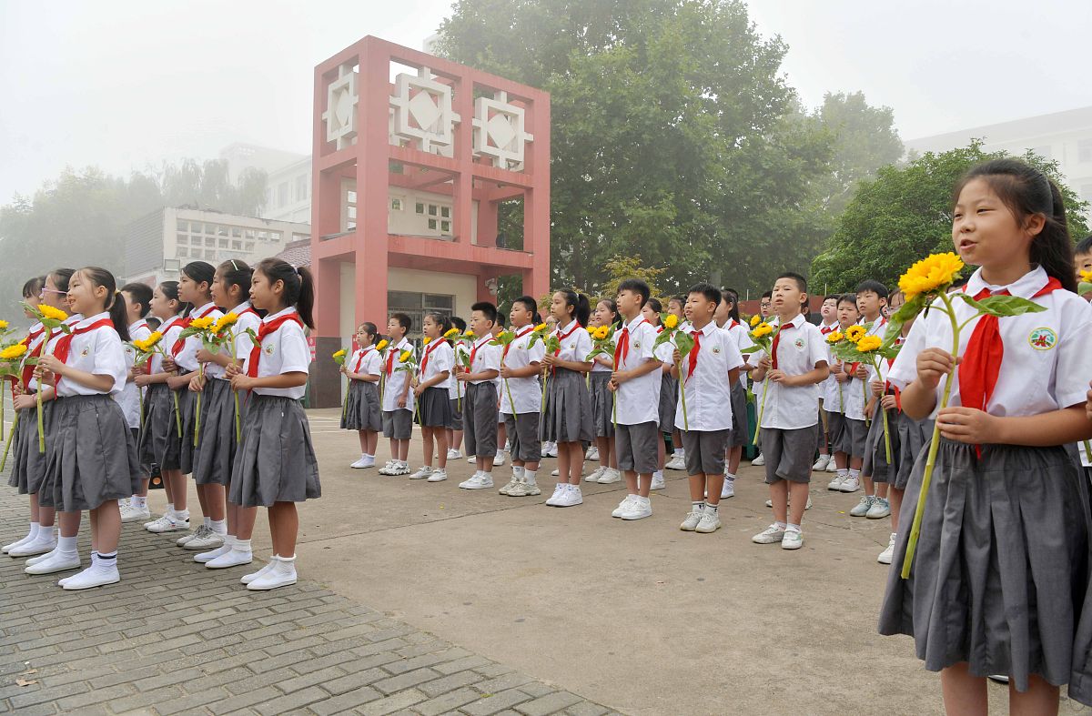 2021年9月10日,江苏省连云港市东海县和平路小学校门口处,少先队员向
