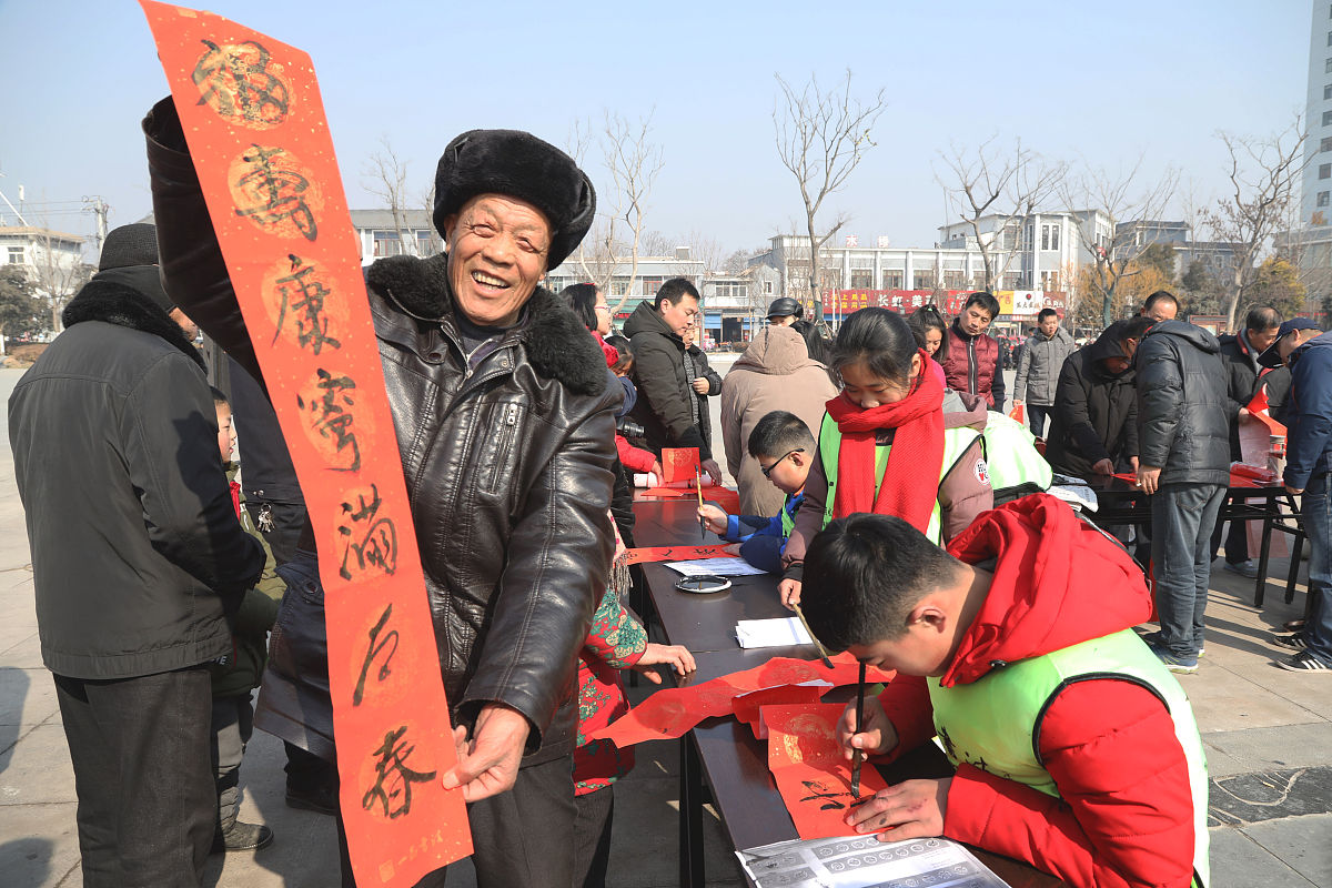 2018年2月7日,江苏徐州,青少年"书法家"为市民书写春联.