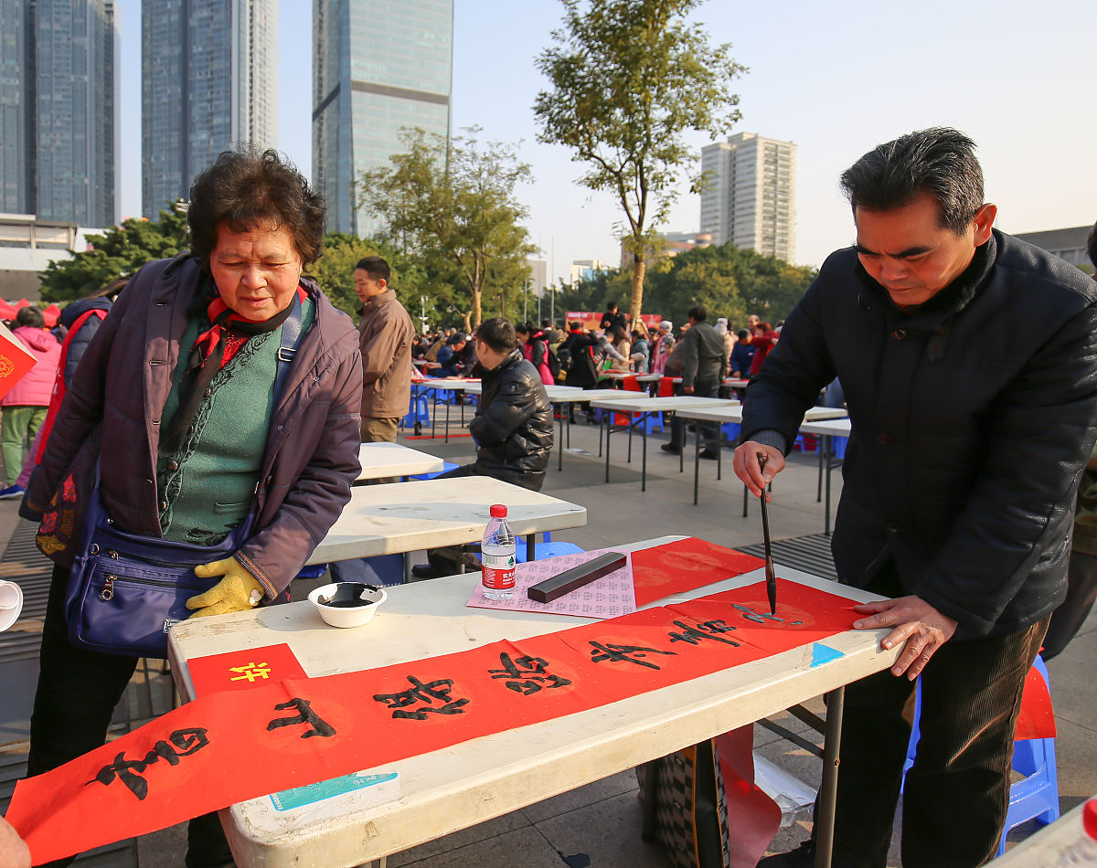 2018年2月3日,广西柳州,书法家为市民书写春联.