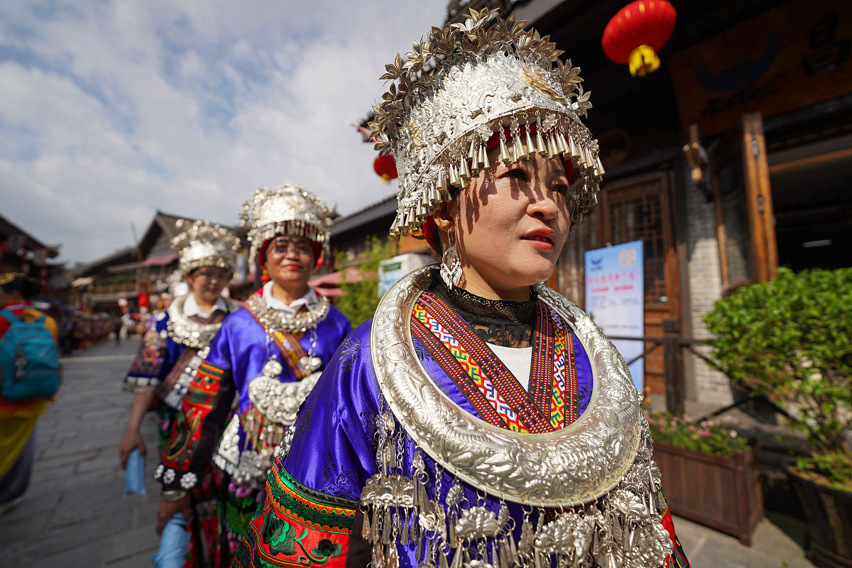 2021年5月15日,贵州黔东南,身着盛装的苗族群众在丹寨万达小镇进行巡