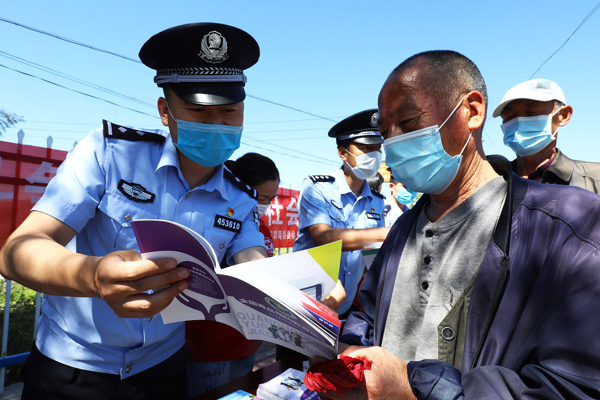 2020年6月23日,新疆阿勒泰,民警正在利用宣传册向辖