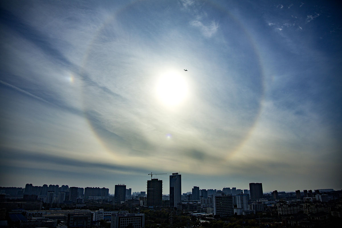2015年12月04日,安徽合肥,合肥城市上空出现罕见的日晕景观.一架飞机