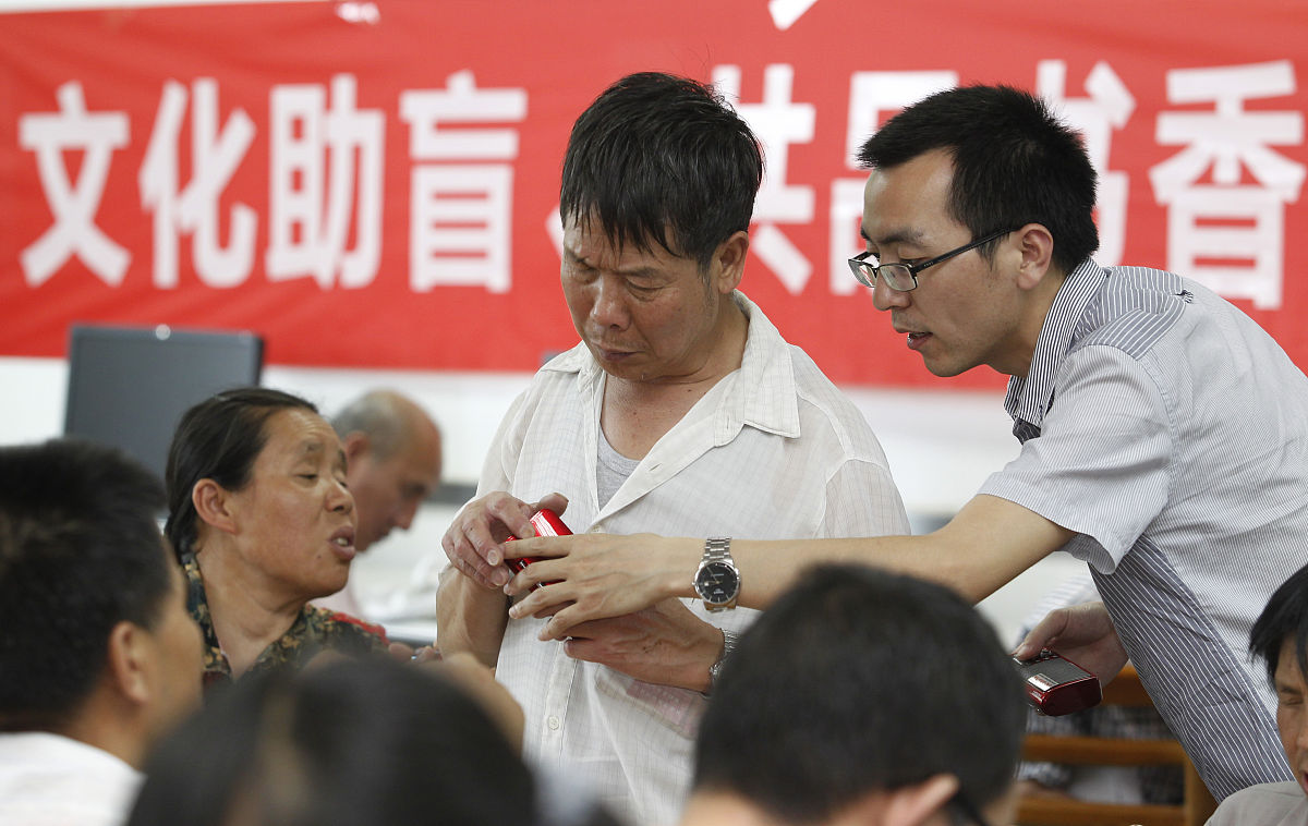 2014年4月23日,云南昆明,云南省图书馆盲人阅览室,工作人员为盲人读者